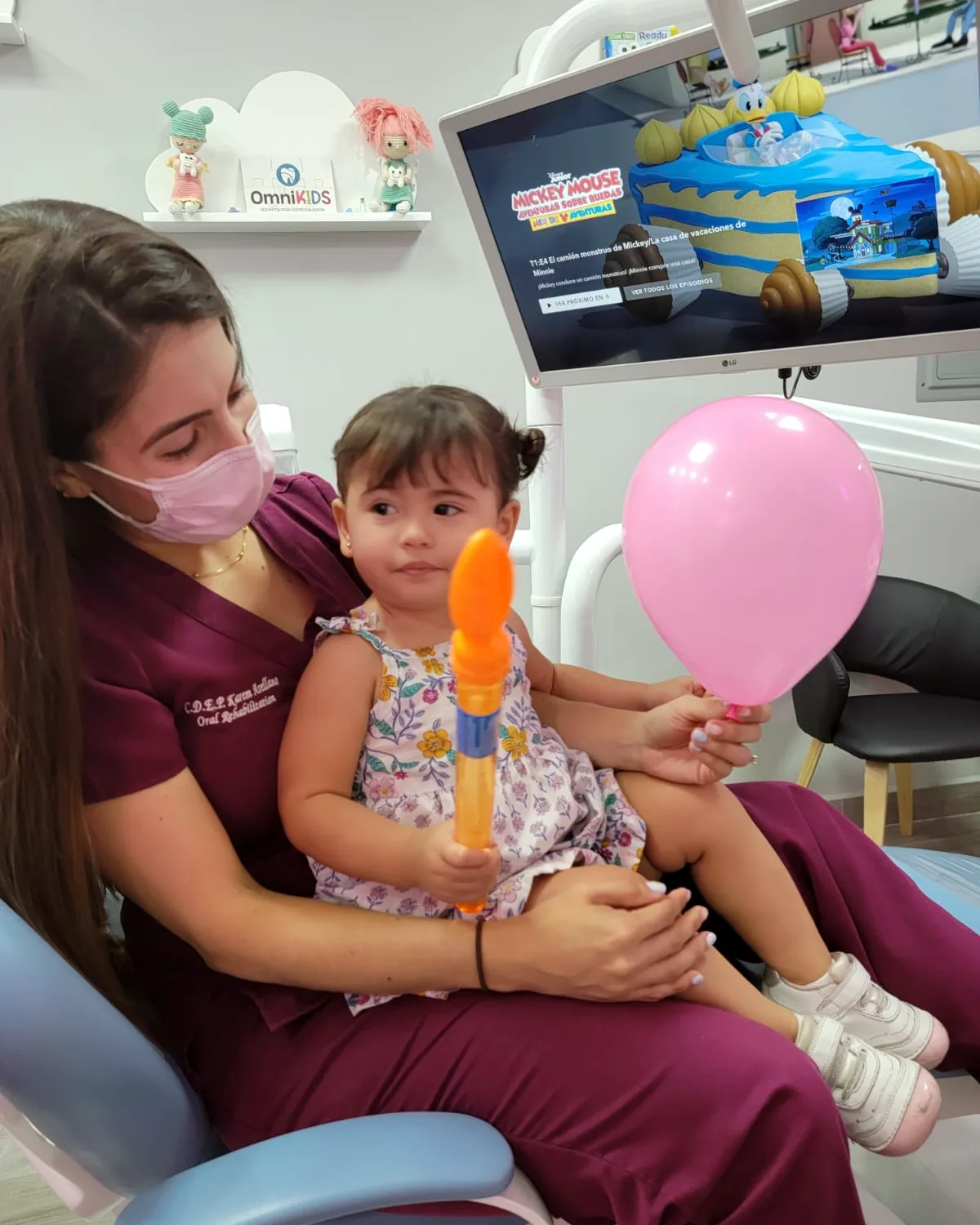 Odontopediatra con un bebé y un globo
