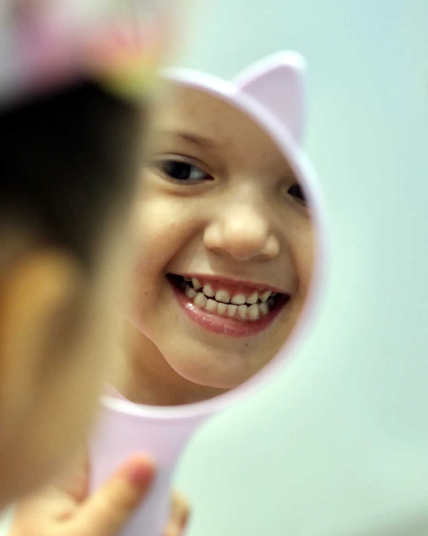 Niña viendo su sonrisa en el espejo